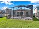 View of home's screened-in back patio, lush backyard and fencing, creating a private outdoor space at 2934 Living Coral Dr, Odessa, FL 33556