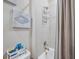 Bathroom showing tub shower, neutral walls, and decorative seashell art at 2934 Living Coral Dr, Odessa, FL 33556