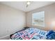 Bedroom with window, ceiling fan, and a colorful quilt on the bed at 2934 Living Coral Dr, Odessa, FL 33556