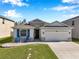 Charming single-story home featuring stone accents, a two-car garage, and a welcoming front porch at 2934 Living Coral Dr, Odessa, FL 33556