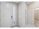 Bright foyer with a white front door and view of the bathroom, creating a welcoming entrance at 2934 Living Coral Dr, Odessa, FL 33556