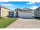 Inviting single-story house with a two-car garage, stone details, and a well-kept lawn at 2934 Living Coral Dr, Odessa, FL 33556