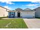 Lovely home with stone veneer, a two-car garage, and a lush green lawn in a suburban setting at 2934 Living Coral Dr, Odessa, FL 33556