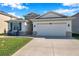 Beautifully landscaped home featuring a two-car garage, stone accents, and manicured lawn at 2934 Living Coral Dr, Odessa, FL 33556