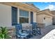 Inviting front porch with stone accents, two rocking chairs, and a window with blue shutters at 2934 Living Coral Dr, Odessa, FL 33556