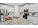 Modern kitchen featuring white cabinets, stainless steel appliances, and granite countertops at 2934 Living Coral Dr, Odessa, FL 33556