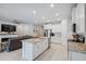 Open-concept kitchen with white cabinets, stainless steel appliances, and a large island at 2934 Living Coral Dr, Odessa, FL 33556