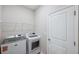 Convenient laundry room with modern washer, dryer, wire shelving, and door at 2934 Living Coral Dr, Odessa, FL 33556