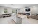 Open-concept living space with kitchen island, dining area, and living room in a sunlit area at 2934 Living Coral Dr, Odessa, FL 33556
