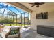 Spacious screened lanai with outdoor dining area, lounge furniture, and a clear backyard view at 2934 Living Coral Dr, Odessa, FL 33556