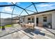 Screened-in patio with dining set, grill, outdoor seating, backyard views, and tiled flooring at 2934 Living Coral Dr, Odessa, FL 33556