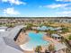 Aerial view of community pools with lounge chairs, palm trees, and covered patios at 2934 Living Coral Dr, Odessa, FL 33556