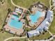 Aerial view of community pools with lounge chairs, palm trees, cabanas, and landscaping at 2934 Living Coral Dr, Odessa, FL 33556