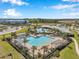 Aerial view of community pools with lounge chairs, palm trees, and covered patios at 2934 Living Coral Dr, Odessa, FL 33556