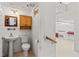 A convenient half bathroom with a pedestal sink, cabinet, and nearby access to the garage at 3010 82Nd N Way, St Petersburg, FL 33710