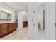 Bathroom with double vanity, decorative mirror and lighting, and closet access at 3010 82Nd N Way, St Petersburg, FL 33710