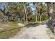 A gravel park path winding through trees and green grass leading to a park facility at 3010 82Nd N Way, St Petersburg, FL 33710