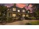 Charming two-story home with a welcoming front porch, beautifully landscaped yard, and warm lighting at 3010 82Nd N Way, St Petersburg, FL 33710