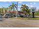 Jungle JP Tavern view showcases the building's design and signage along with palm trees and vehicles at 3010 82Nd N Way, St Petersburg, FL 33710