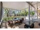 Screened porch with wooden floors, glass topped table and comfortable seating with backyard view at 3010 82Nd N Way, St Petersburg, FL 33710