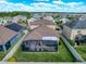 Aerial view of a home with a screened patio, fenced yard, and lush green surroundings in a residential neighborhood at 32101 Goddard Dr, Wesley Chapel, FL 33543