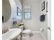 Bright half bathroom featuring a pedestal sink, white fixtures, and window with natural light at 32101 Goddard Dr, Wesley Chapel, FL 33543