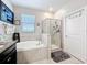 Bright bathroom featuring a soaking tub and glass-enclosed shower, designed for relaxation and convenience at 32101 Goddard Dr, Wesley Chapel, FL 33543