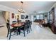 Open-concept dining room and living room with tile floors, wooden table, and an adjacent staircase at 32101 Goddard Dr, Wesley Chapel, FL 33543