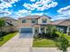 Beautiful two-story home with a well-manicured lawn, blue accents, and inviting front porch with rocking chairs at 32101 Goddard Dr, Wesley Chapel, FL 33543