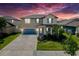 Charming two-story home with blue accents, a manicured lawn, and an attached two-car garage at 32101 Goddard Dr, Wesley Chapel, FL 33543
