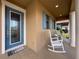 Inviting front porch with rocking chairs, blue door, and well-maintained landscaping creating a welcoming entrance at 32101 Goddard Dr, Wesley Chapel, FL 33543