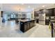 Open-concept kitchen featuring dark cabinetry, granite countertops, stainless steel appliances, and a large center island at 32101 Goddard Dr, Wesley Chapel, FL 33543