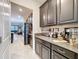 Stylish kitchen with dark cabinets, granite countertops, stainless steel appliances, and an open layout to the living area at 32101 Goddard Dr, Wesley Chapel, FL 33543