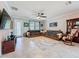 Cozy living room features a ceiling fan, comfortable sofa, decorative rug, and a glass door to the outside at 32101 Goddard Dr, Wesley Chapel, FL 33543