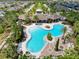 Aerial view of a community pool and clubhouse surrounded by palm trees, offering a resort-style experience at 32101 Goddard Dr, Wesley Chapel, FL 33543