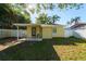 Backyard features a covered patio with furniture, privacy fence, and sunny skies at 3451 Pine St, Dunedin, FL 34698