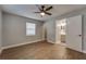 Relaxing bedroom features wood-look floors, ceiling fan, and ensuite bathroom for added privacy at 3451 Pine St, Dunedin, FL 34698