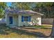 Charming home featuring light yellow siding, a blue door, and vibrant blue shutters at 3451 Pine St, Dunedin, FL 34698