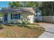 Side exterior of home with blue shutters and green trash can at 3451 Pine St, Dunedin, FL 34698