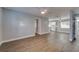 Spacious living room with updated light fixtures, wood flooring, and view to the kitchen at 3451 Pine St, Dunedin, FL 34698