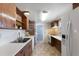 Cozy kitchen featuring tile floor, wood cabinets, stainless sink, and white appliances at 3726 Prescott N St, St Petersburg, FL 33713