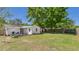 Spacious backyard with patio, barbecue, seating, and lush green lawn under mature trees at 39233 9Th Ave, Zephyrhills, FL 33542