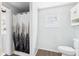 Bathroom featuring a toilet, cabinet, window and shower with nature-themed curtain at 39233 9Th Ave, Zephyrhills, FL 33542