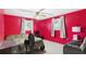 Bedroom showcasing vibrant red walls, carpet floors, ceiling fan, and two windows with blinds at 39233 9Th Ave, Zephyrhills, FL 33542