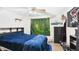 Bedroom with bed, wood floors, ceiling fan, forest tapestry, and pirate flag at 39233 9Th Ave, Zephyrhills, FL 33542