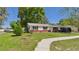 Traditional single-story home showing mature trees and shrubs in a well-maintained front yard at 39233 9Th Ave, Zephyrhills, FL 33542