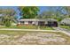 Charming single-story home featuring a well-manicured lawn, brick accents, and a covered carport at 39233 9Th Ave, Zephyrhills, FL 33542
