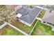 Aerial view of a home showcasing solar panels, a fenced yard, and neighborhood landscape at 4262 Larkenheath Dr, Spring Hill, FL 34609