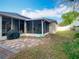 View of the screened-in lanai and patio area in a backyard with a well manicured lawn at 4262 Larkenheath Dr, Spring Hill, FL 34609