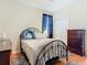 Charming bedroom with a metal frame bed, hardwood floors, closet and patterned rug at 4262 Larkenheath Dr, Spring Hill, FL 34609